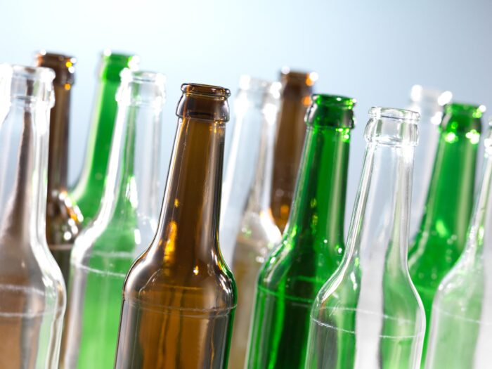 Shoulder and neck of multiple coloured empty glass bottles